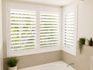 White plantation shutters in corner window in bathroom