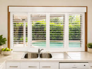 sliding plantation shutters above kitchen sink over looking pool 
