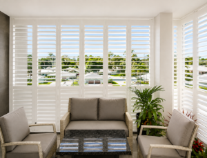 Bi-folding plantation shutters white in corner unit balcony full height  shutters