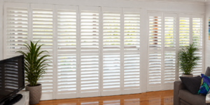 Bi folding shutters white next to hinged shutters wooden floor full height lounge 